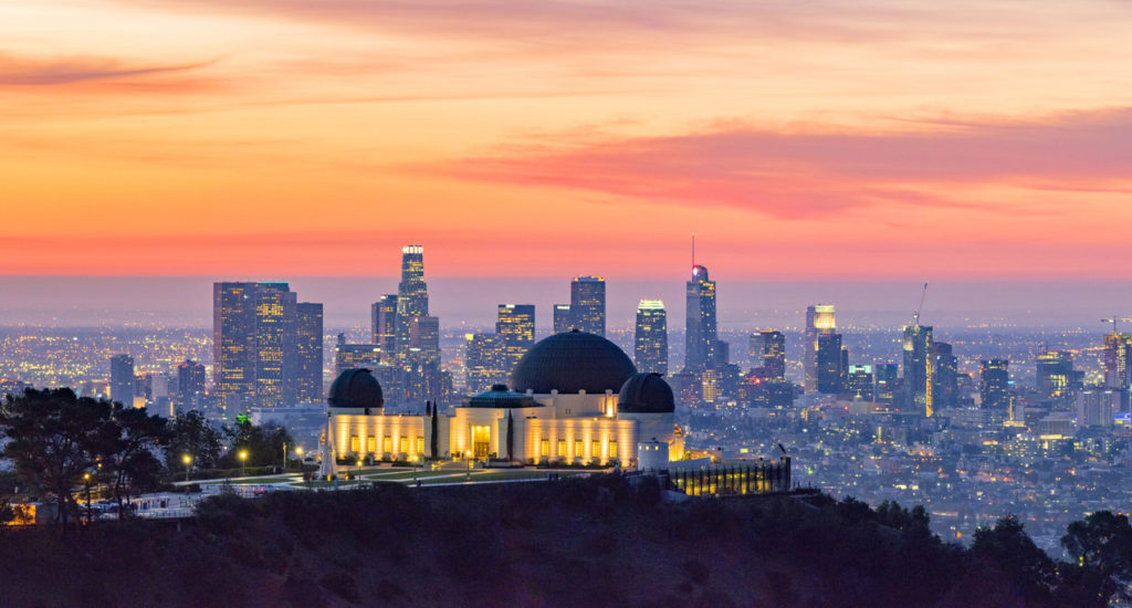 Los Angeles skyline at dawn with Griffith Park Observatory in the foreground